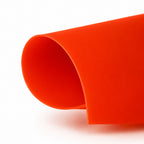 A close-up of a Noosa red minukini, curled at the edge, photographed on a clean white background.